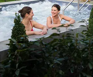 Two women chatting in the hydropool in the Spa Garden