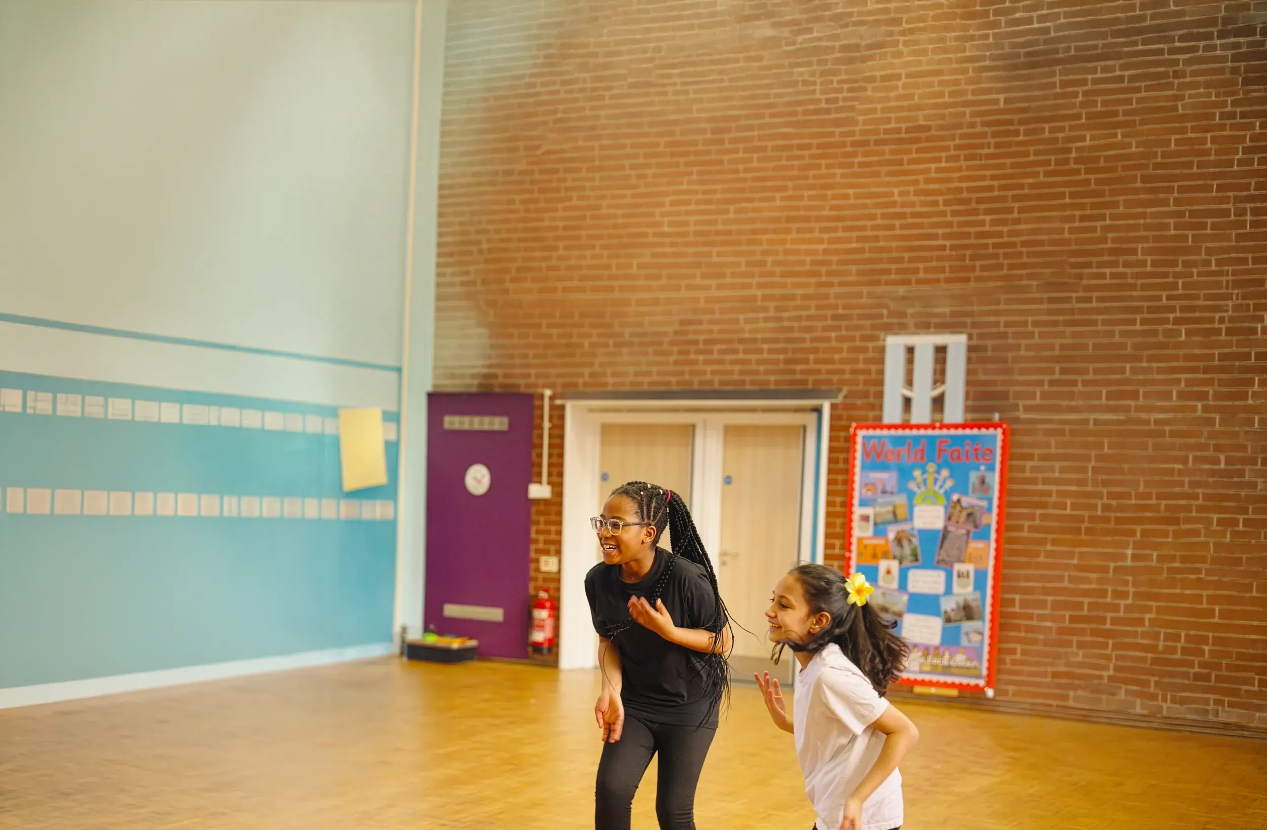 Two girls laughing together in a dance class