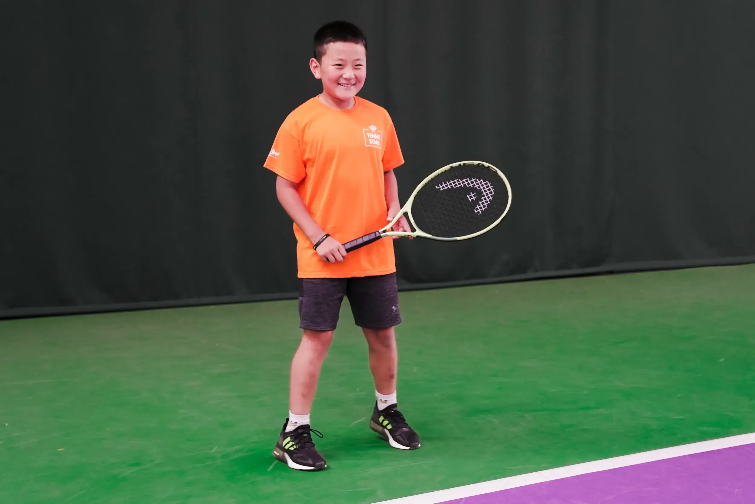 A young boy holding a tennis racquet
